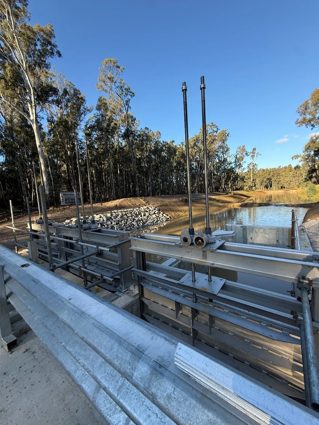 Steel gate valve assembly on a concrete water outlet structure with rock armouring beyond