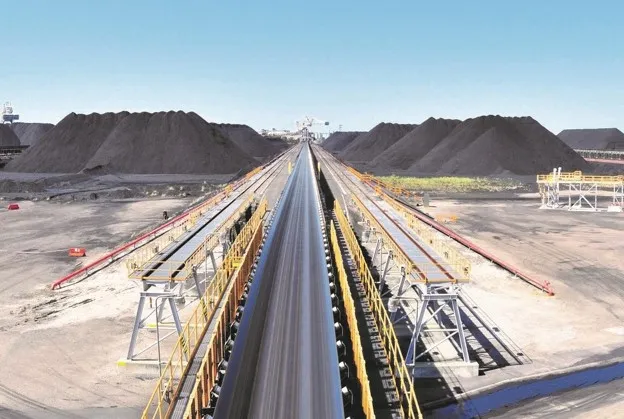 Long overland conveyor running between ore stockpiles at a mine site