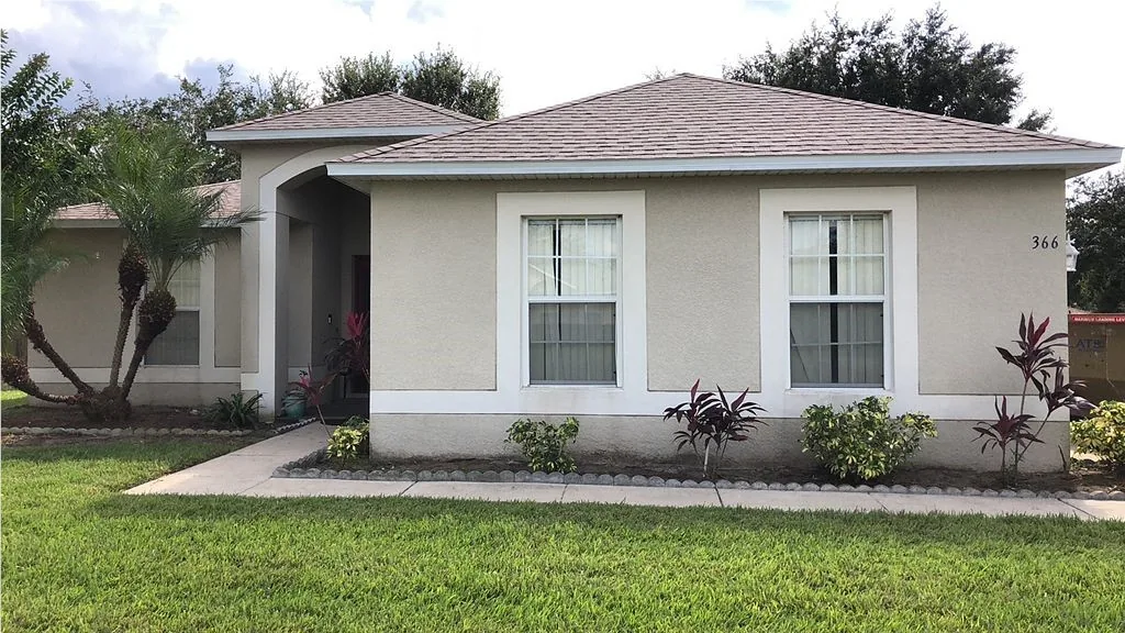 Tan multi-gable Central Florida home with a dark architectural asphalt shingle roof installed by JTO