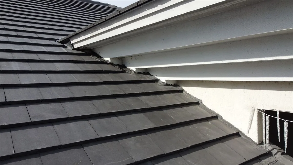 Dark tile roof with white fascia and flashing detail on a JTO tile roofing project