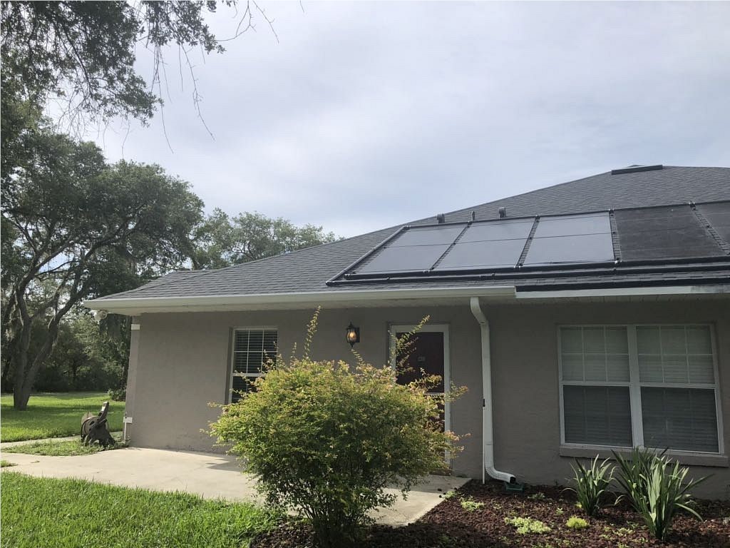 Aerial view of solar panels installed on a home near a pool