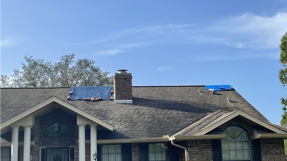 Emergency tarps covering hurricane storm damage on a Central Florida roof