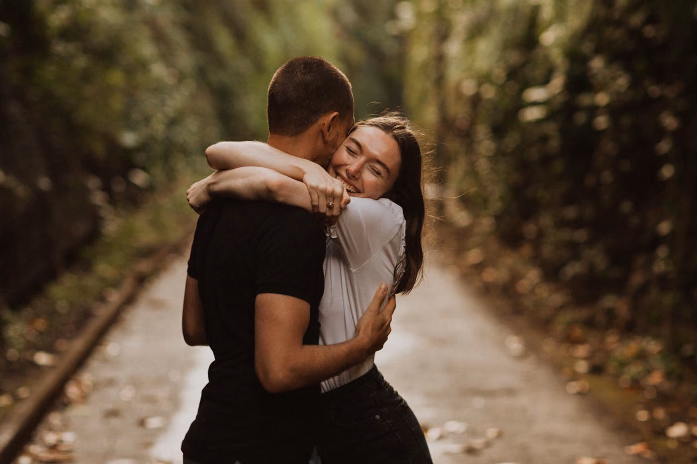 Un homme et une femme s'embrassent et s'enlacent sur un chemin entouré de verdure à la Réunion.