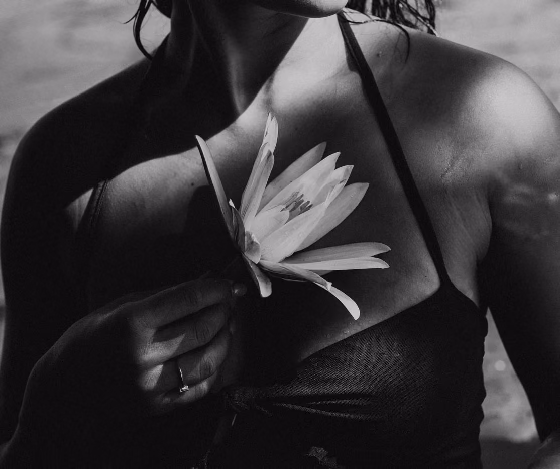 Gros plan noir et blanc en extérieur d'une femme posant dans un bassin de nénuphars à la lumière du soleil couchant à l'Étang Saint-Paul.