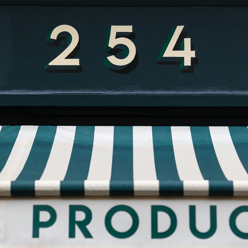 Numéro 254 et auvent rayé vert de l'épicerie Champs Libres boulevard Voltaire