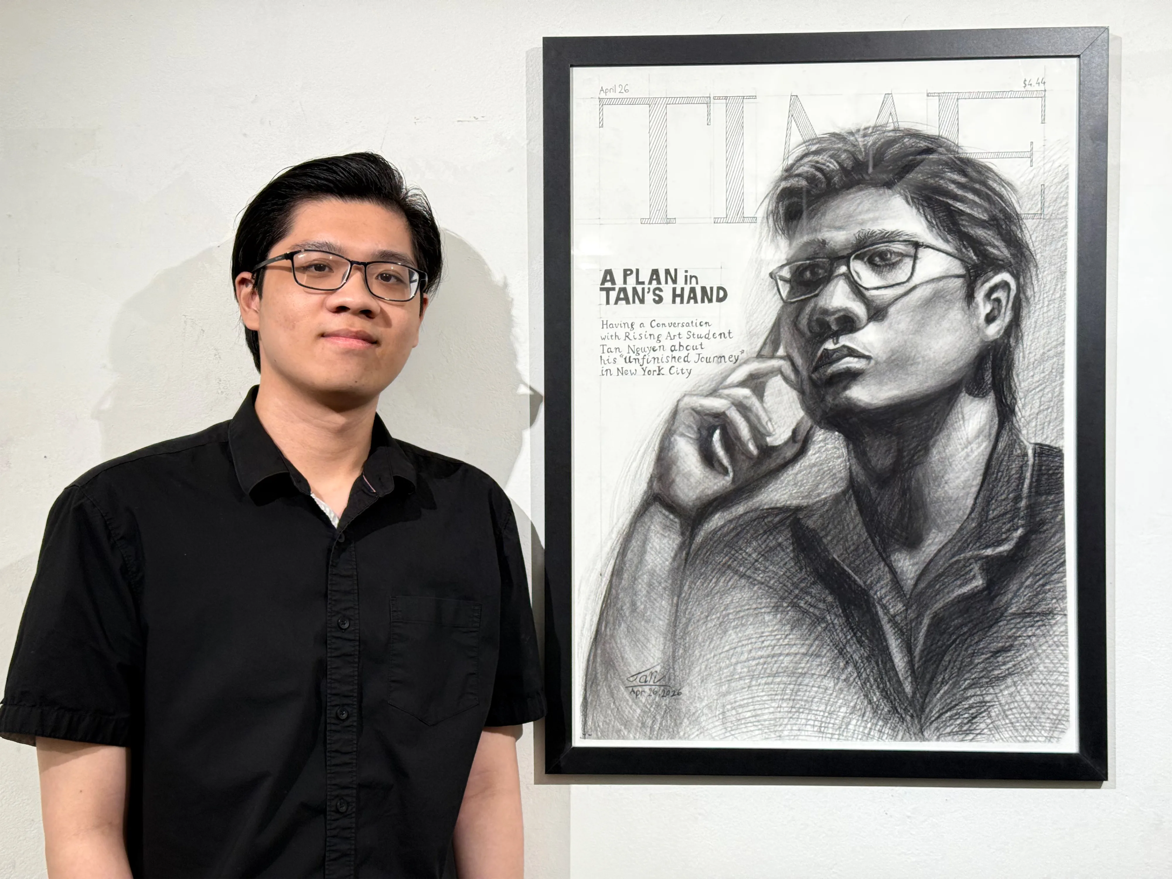 Tan Nguyen standing beside the finished drawing, framed in black and hung on a white wall.