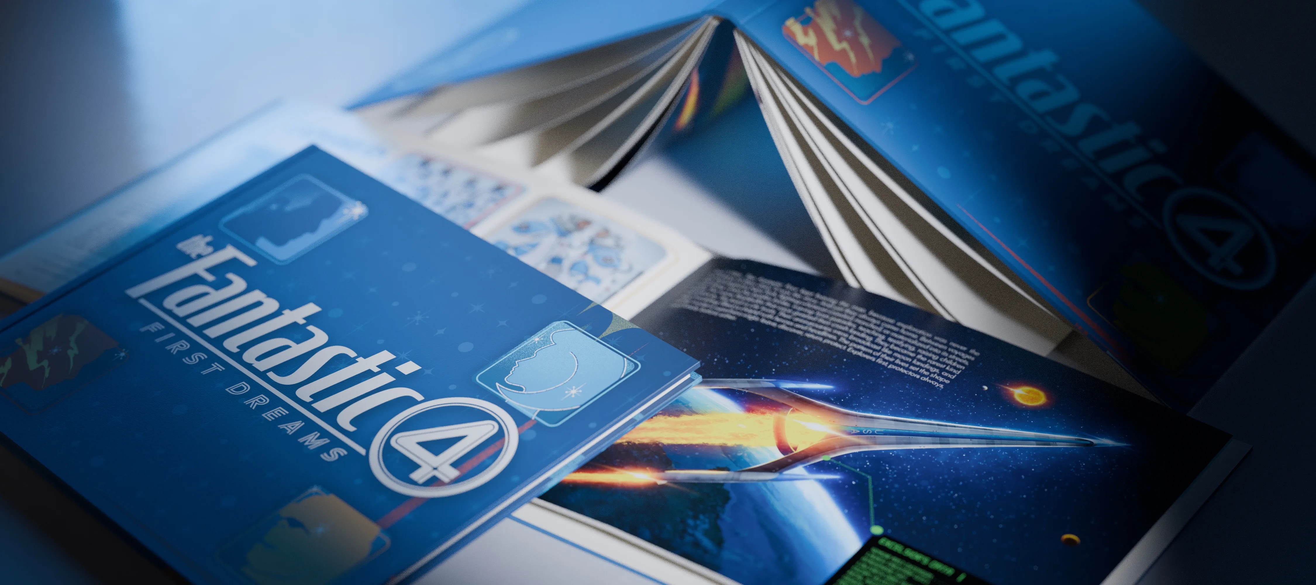 The artbook photographed from the right, the closed cover in front, an open copy showing the Excelsior spread, and a third copy fanned open behind.