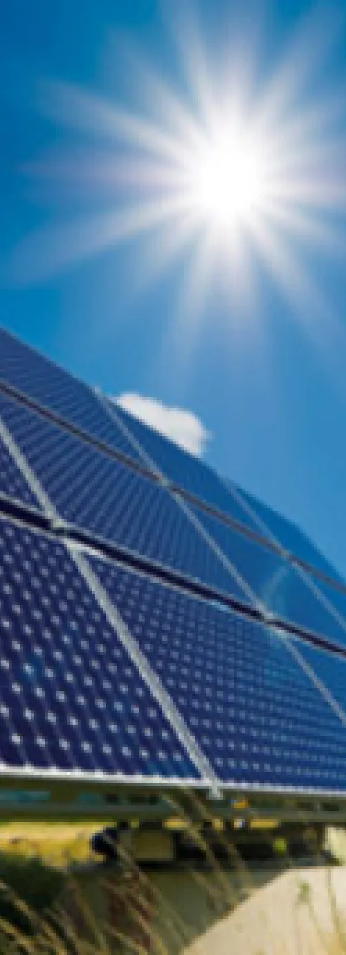 A solar panel with the sun shining over it.