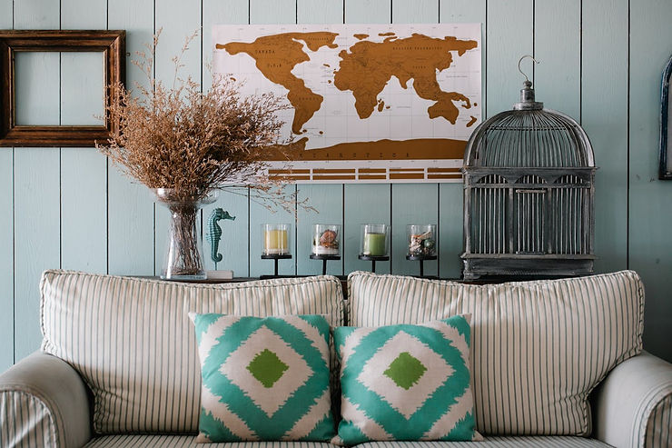 A clean living room decorated with POD posters, pillows, vases, and home décor items