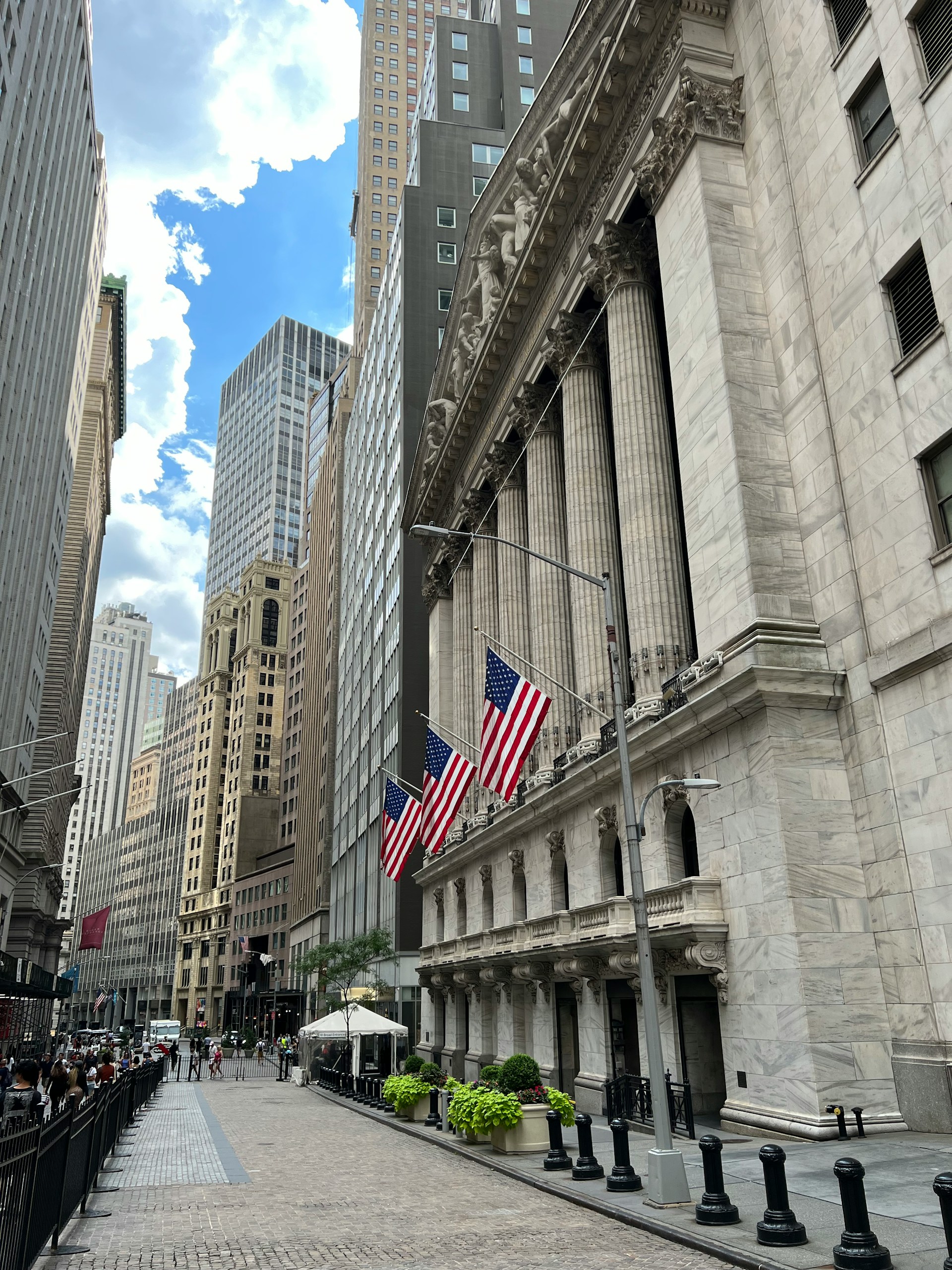 A Financial District street lined with tall buildings and American flags