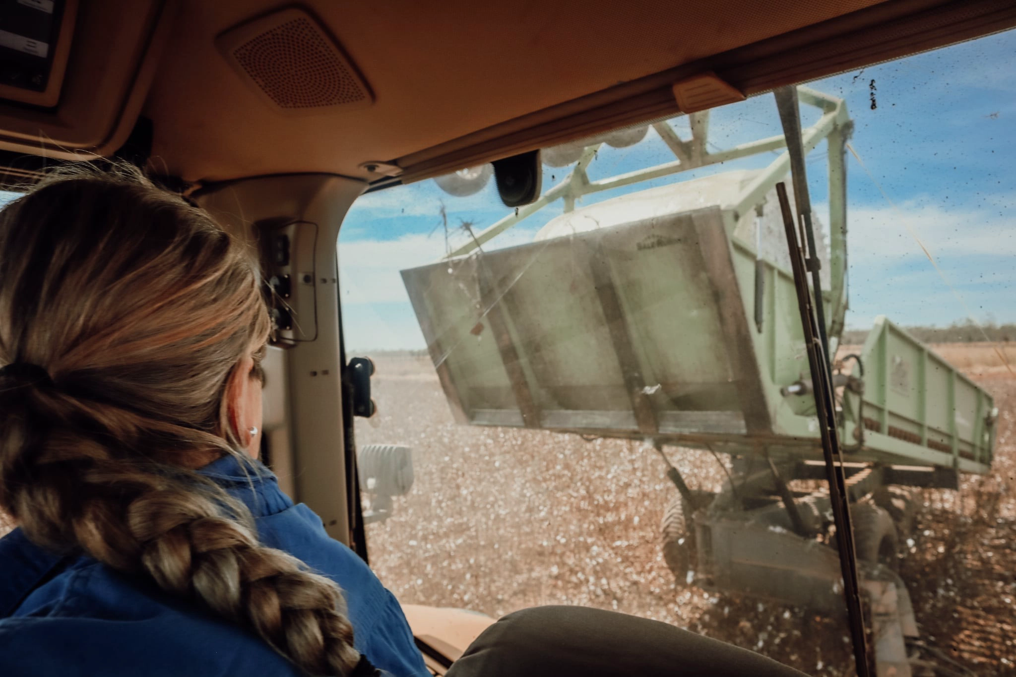 Machinery operator in the cab of a header, Ormsby Group agricultural contracting careers