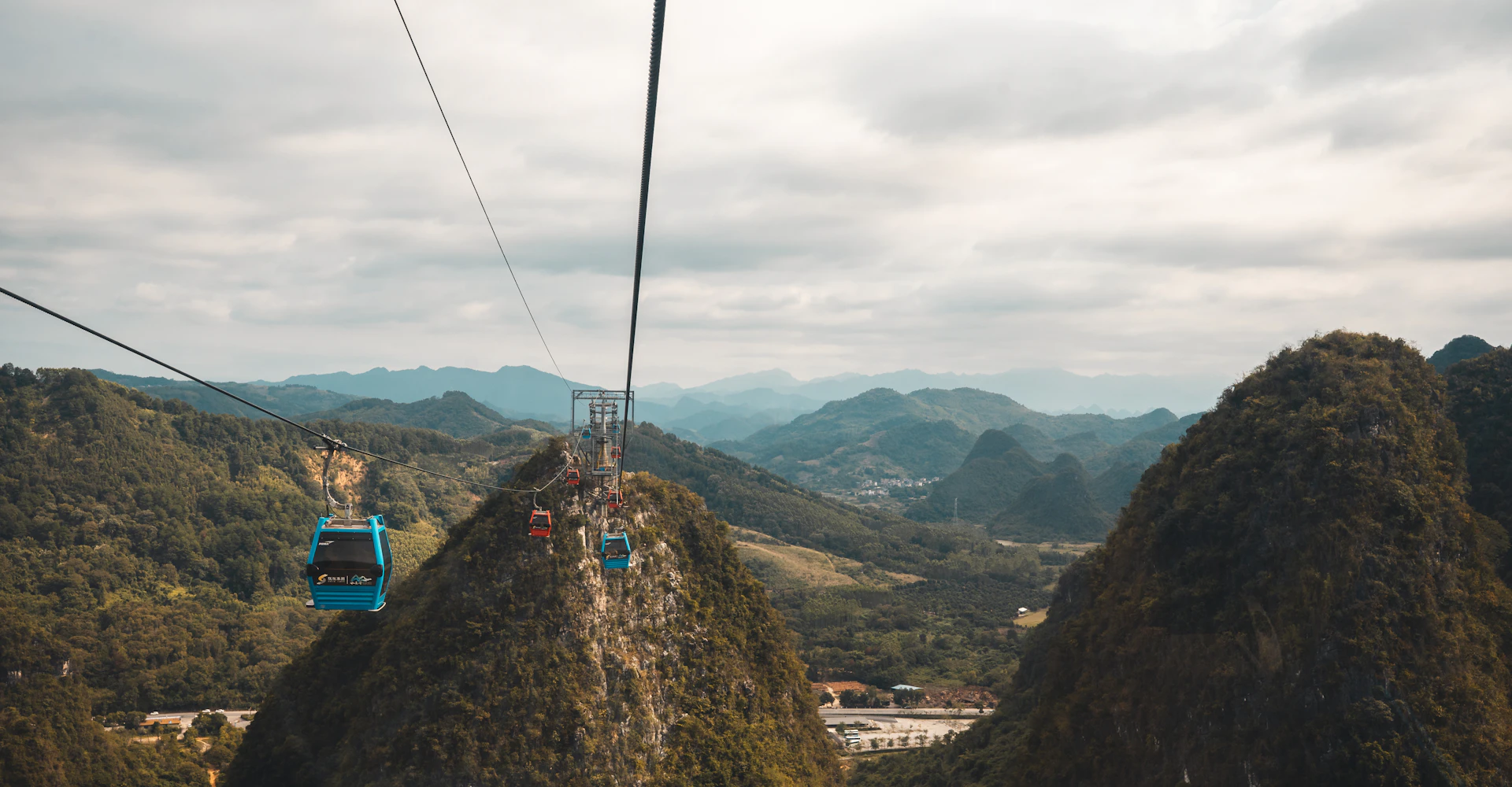 Cable cars ascending over green mountains