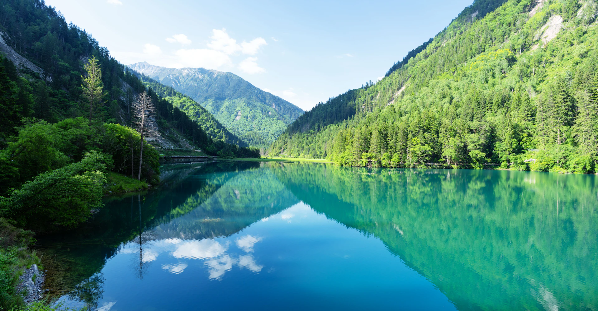 Highland lake ringed by mountains and forest, Huanglong region