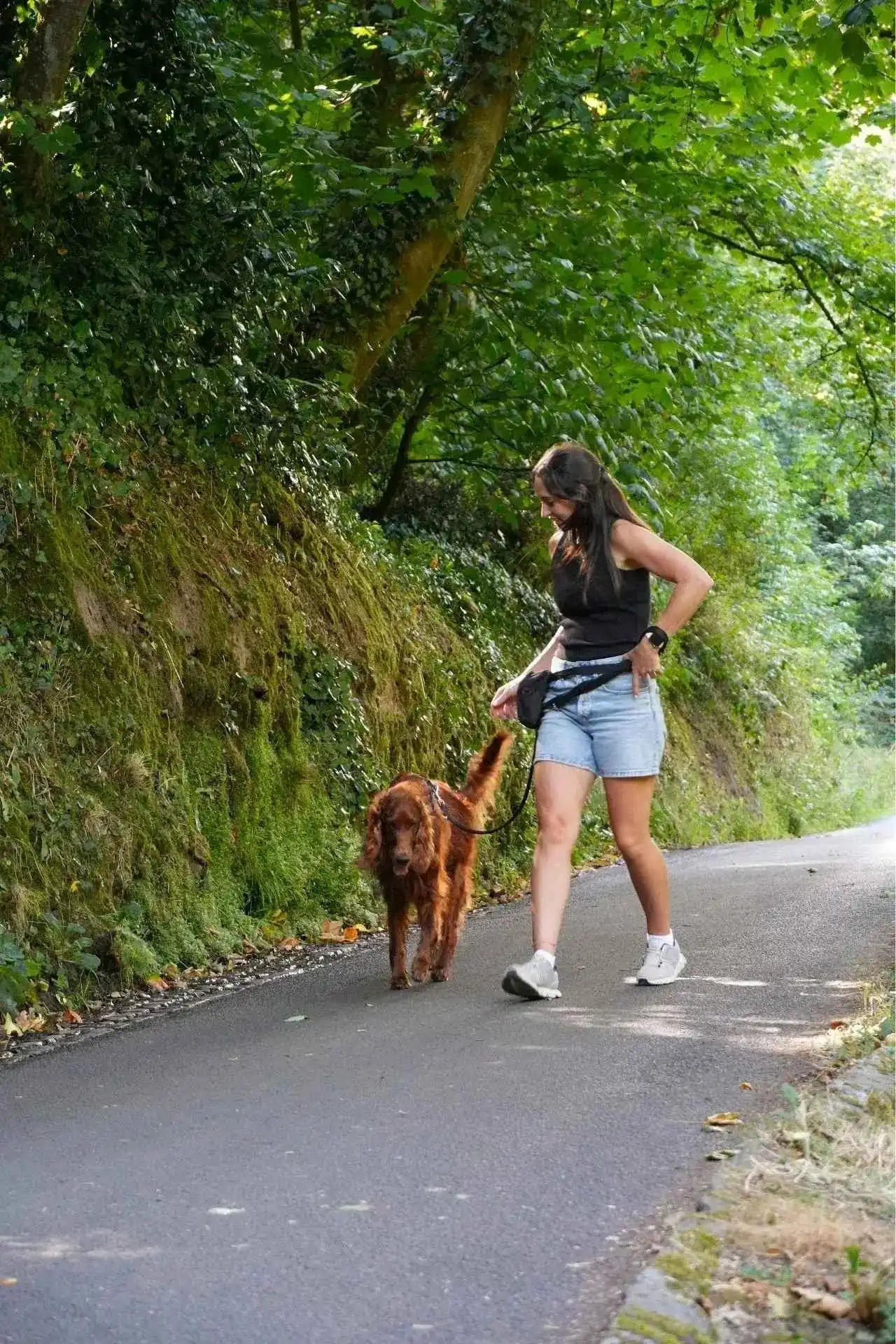 Katie loose lead walking her dog on a coastal path in Guernsey