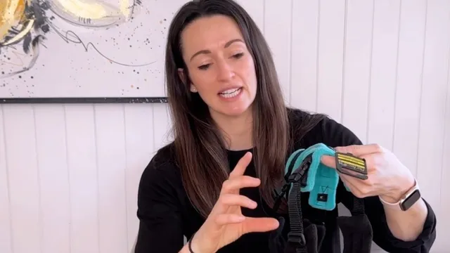 Katie holding up a dog harness