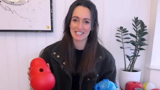 Katie holding multiple dog training toys