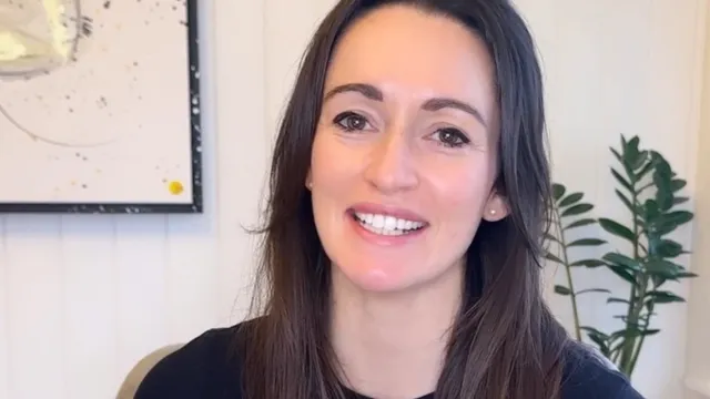 Katie sat smiling in front of camera