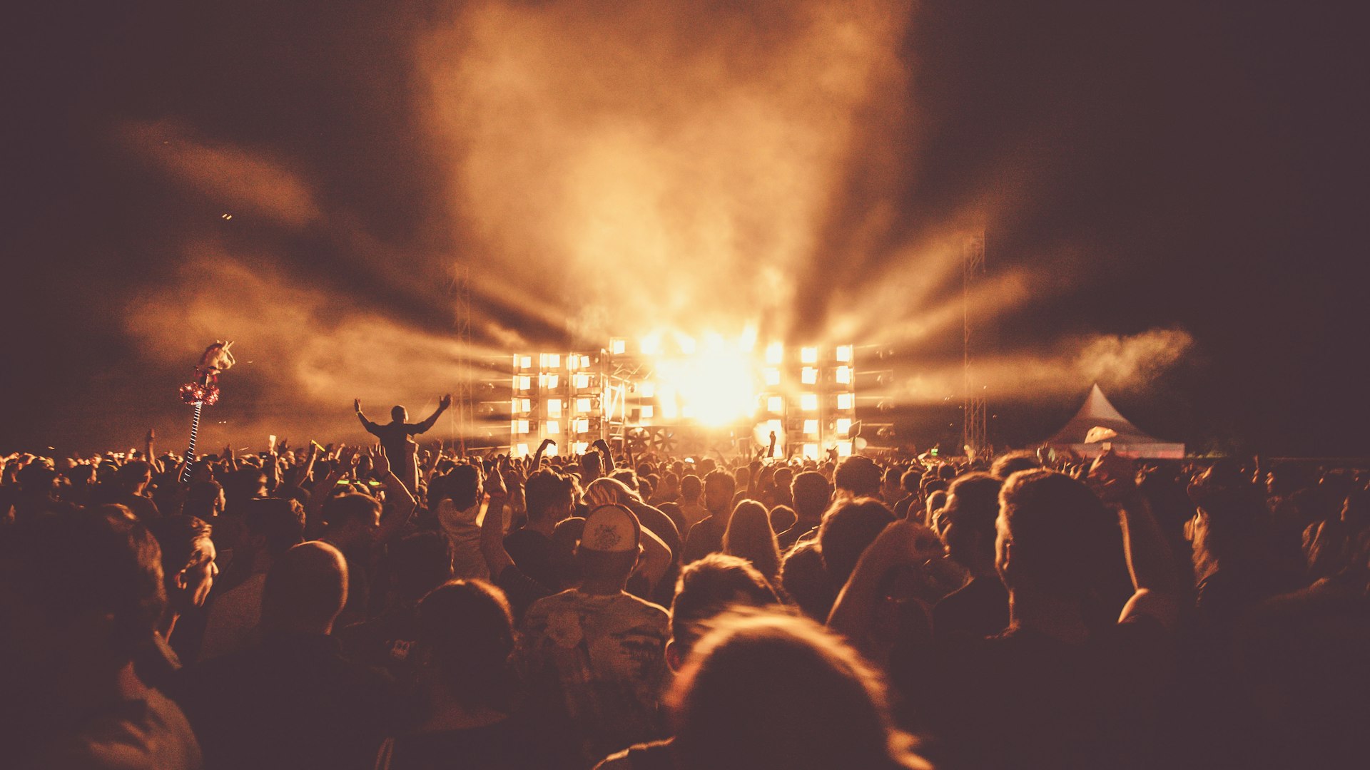 Podium met een felle lichtshow boven een groot publiek