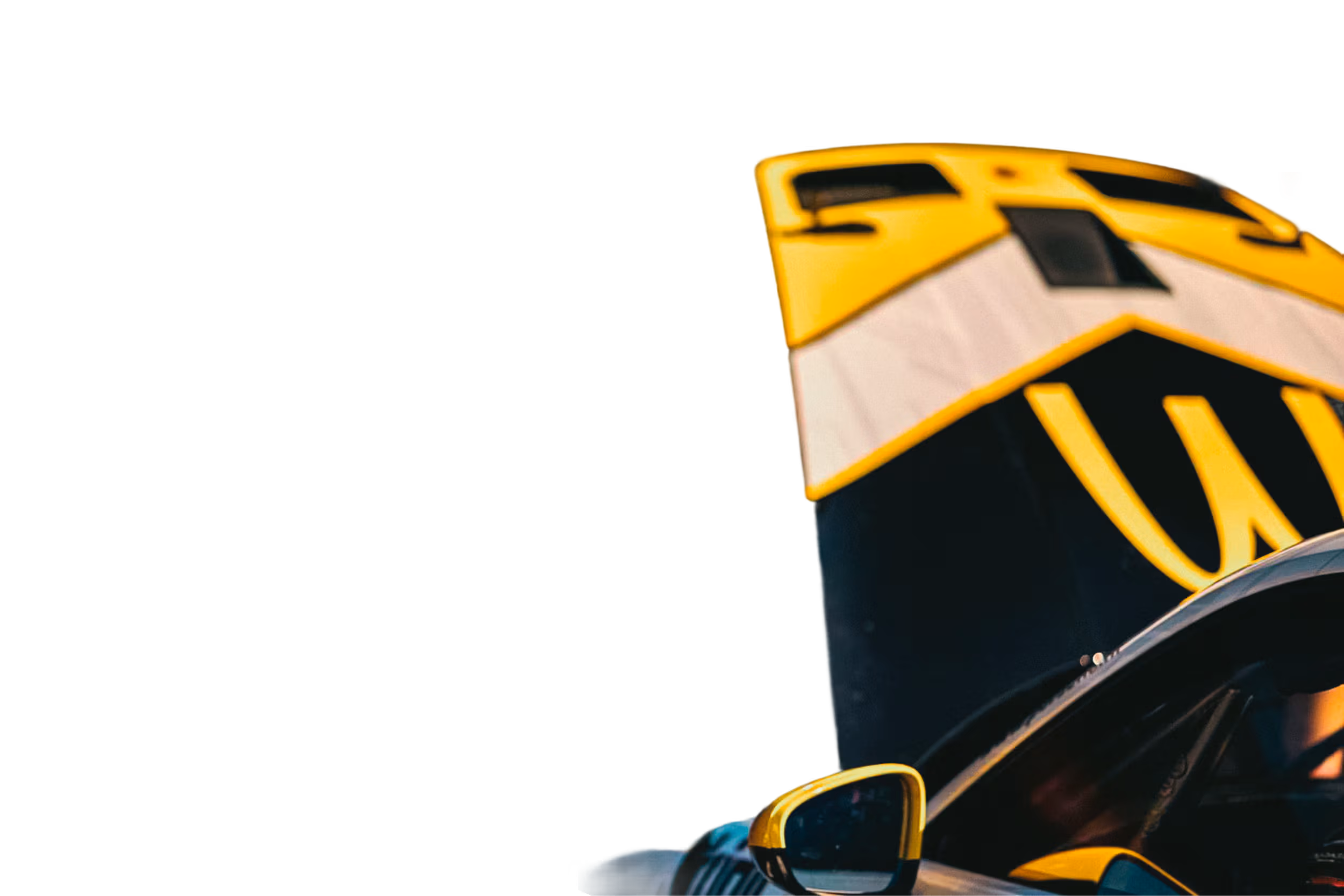Yellow and black racing car wing with adjacent side mirror reflecting a blurred background.