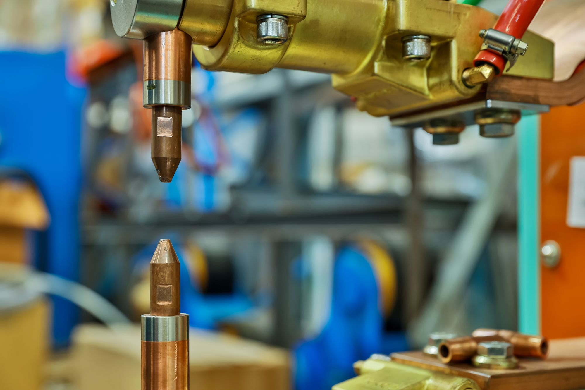 Close-up of copper welding or cutting torch tips in an industrial setting.