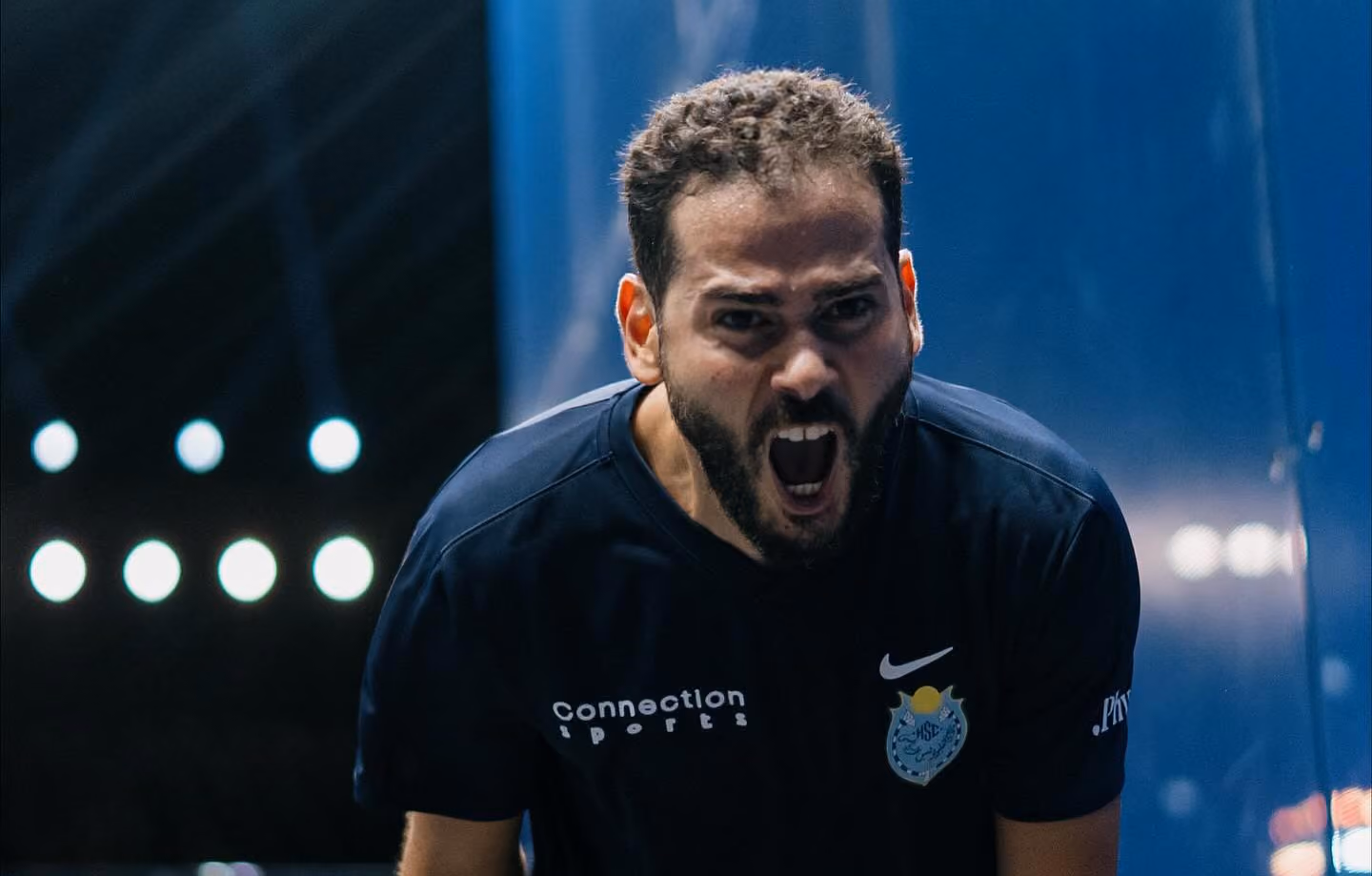 A squash player celebrating a hard fought point.