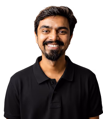 Smiling young man with dark hair, mustache, and beard wearing a black polo shirt against a black background.
