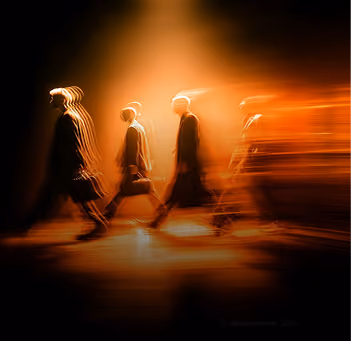 Blurred silhouettes of four people walking from left to right against a warm orange light background, creating a dynamic, motion-filled effect.