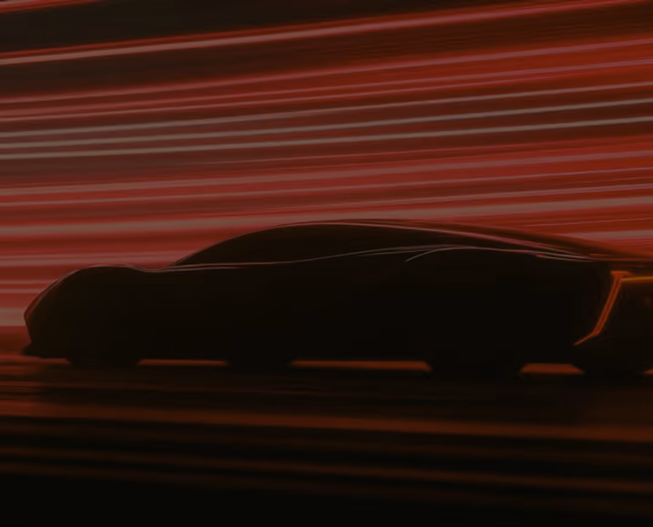 Silhouette of a sleek, futuristic sports car driving against a background of dynamic red and orange horizontal light streaks suggesting speed.