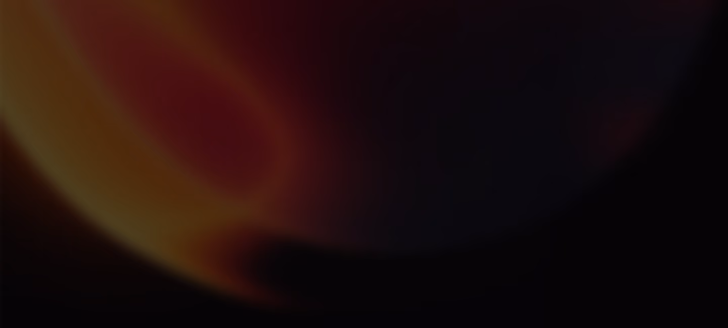 Abstract dark background with a blurred gradient of red, orange, and black colors blending together.