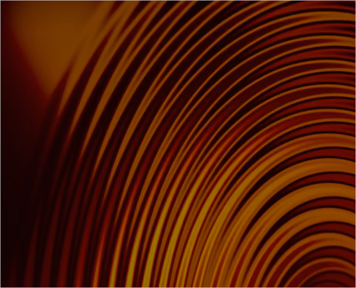Close-up of warm-toned concentric rings creating an abstract pattern with shades of orange, brown, and black.