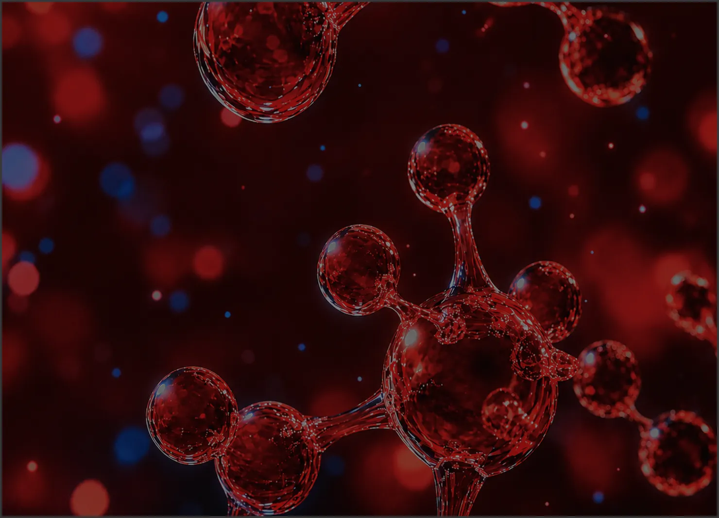 Red molecular or atomic structures resembling connected spheres with a glossy, glass-like appearance against a dark background with red and blue bokeh light effects.