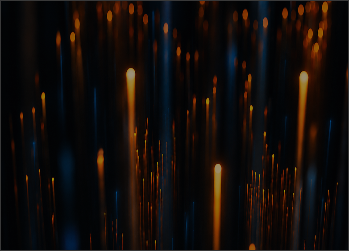 Abstract image of vertical light streaks with glowing orange and blue hues on a dark background.