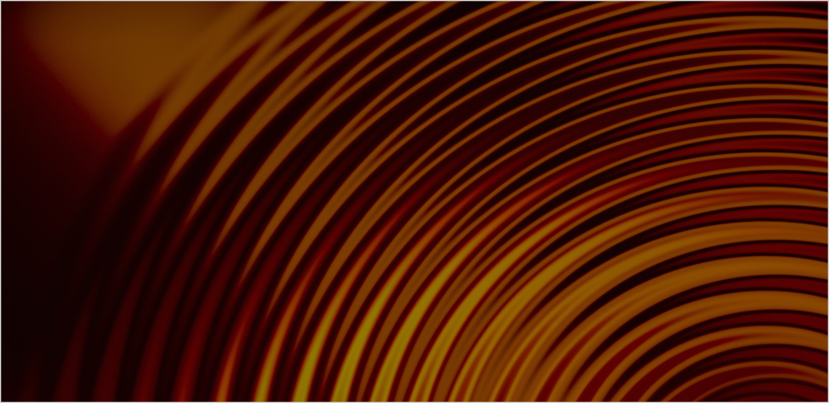 Close-up of concentric circular waves in warm colors ranging from dark red to golden yellow, creating an abstract gradient pattern.