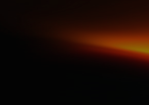 Dark background with a bright orange and yellow glowing light streak on the right side, fading into blackness.