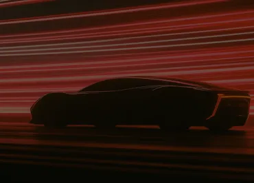 Silhouette of a sleek sports car with red light streaks in the background, suggesting high speed.