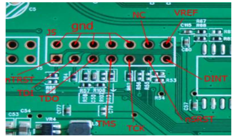 Close-up of a green printed circuit board showing a row of 14 empty circular pins labeled in red text as J5, gnd, NC, VREF, DINT, nSRST, TCK, TMS, TDO, TDI, and nTRST, with nearby electronic components and circuit traces.