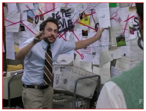 A man in a blue shirt and striped tie stands in front of a wall covered with papers and red string connecting them, gesturing animatedly as he explains something to another person.