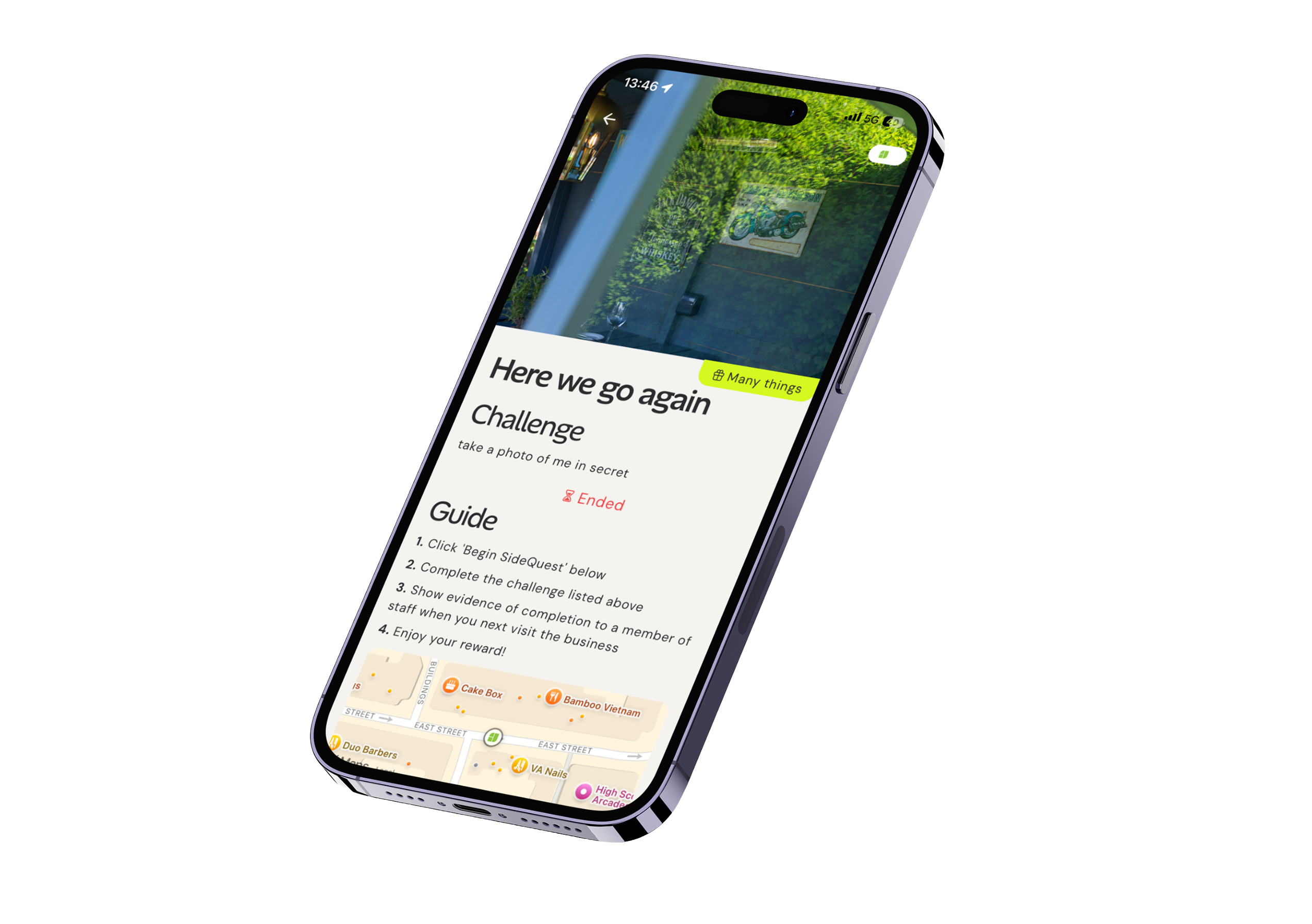 Smartphone displaying a challenge interface titled 'Here we go again' with the task 'take a photo of me in secret' marked as ended. The guide lists four steps: click 'Begin SideQuest,' complete the challenge, show completion evidence to staff, and enjoy the reward. A partial map with local points of interest, including Cake Box and Bamboo Vietnam, is shown at the bottom.