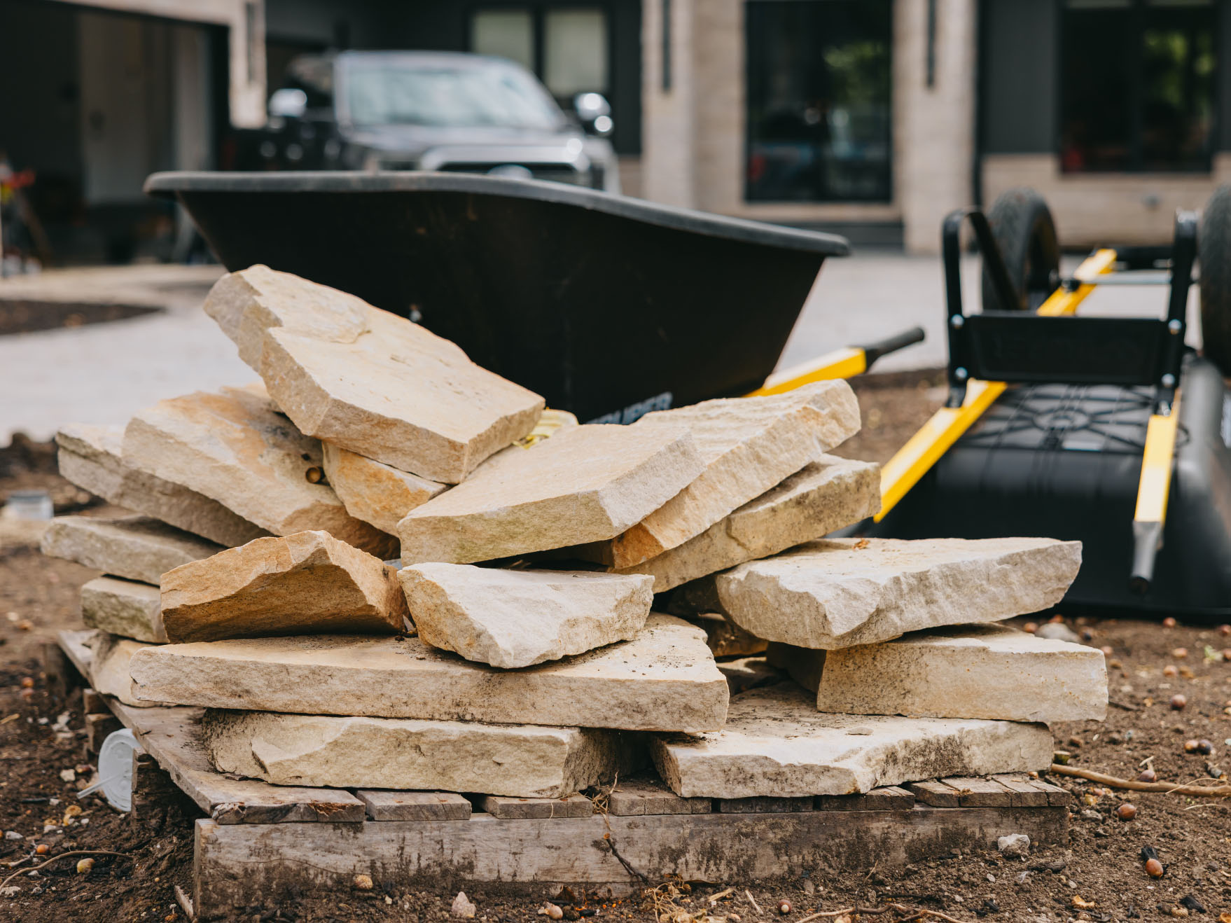 Pallet of natural stone slabs staged on site ready for a pathway installation.