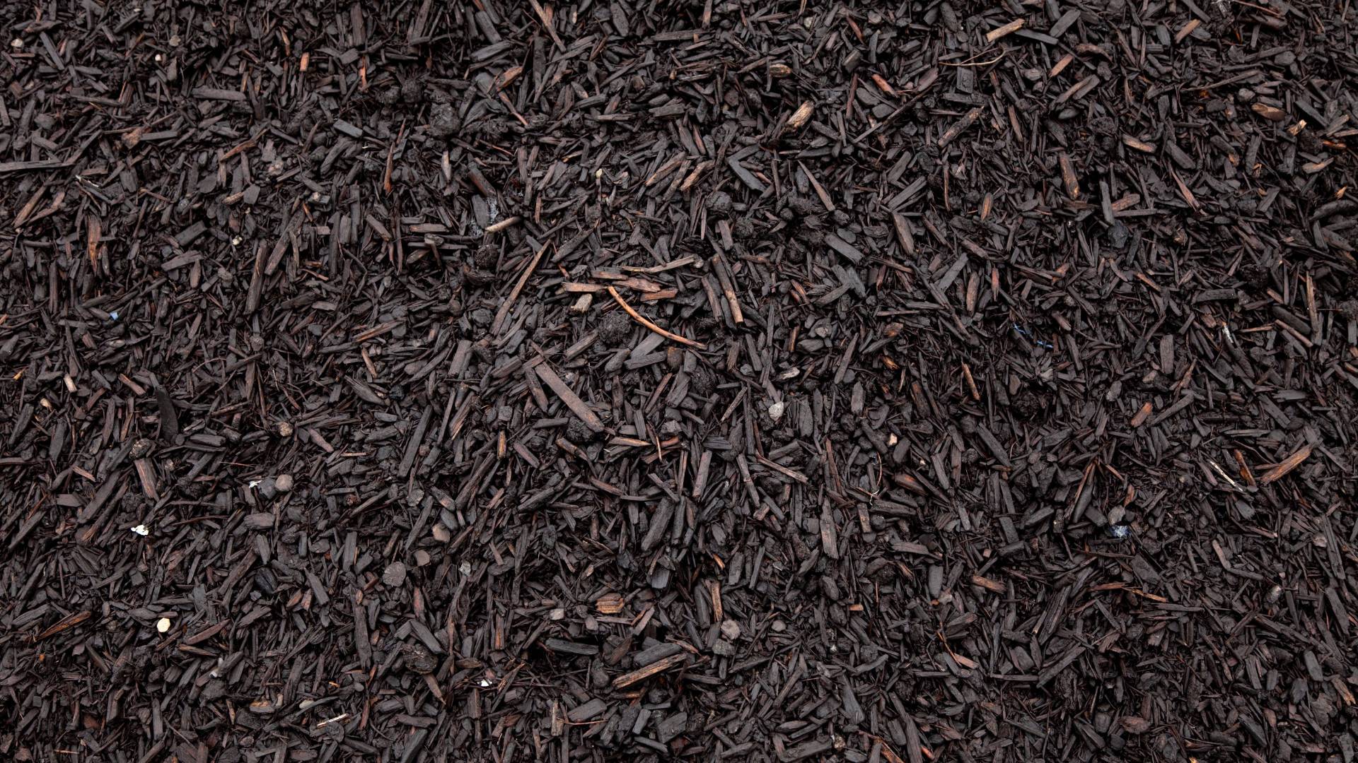 Close-up of premium hardwood mulch material used in Custom Scapes & Designs landscape installations across the Chicago area.