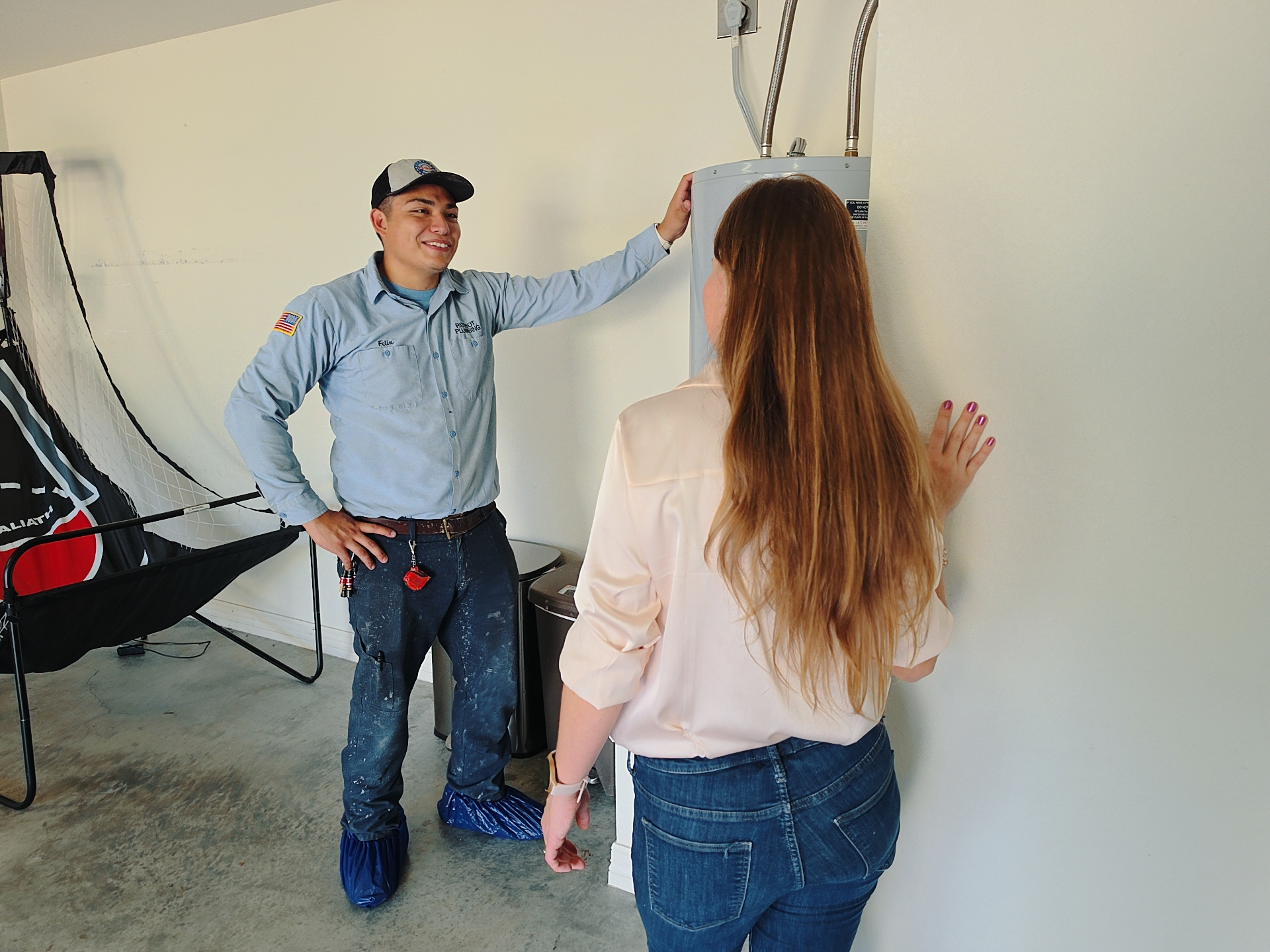 Patriot Plumbing technician discussing a water heater with a homeowner
