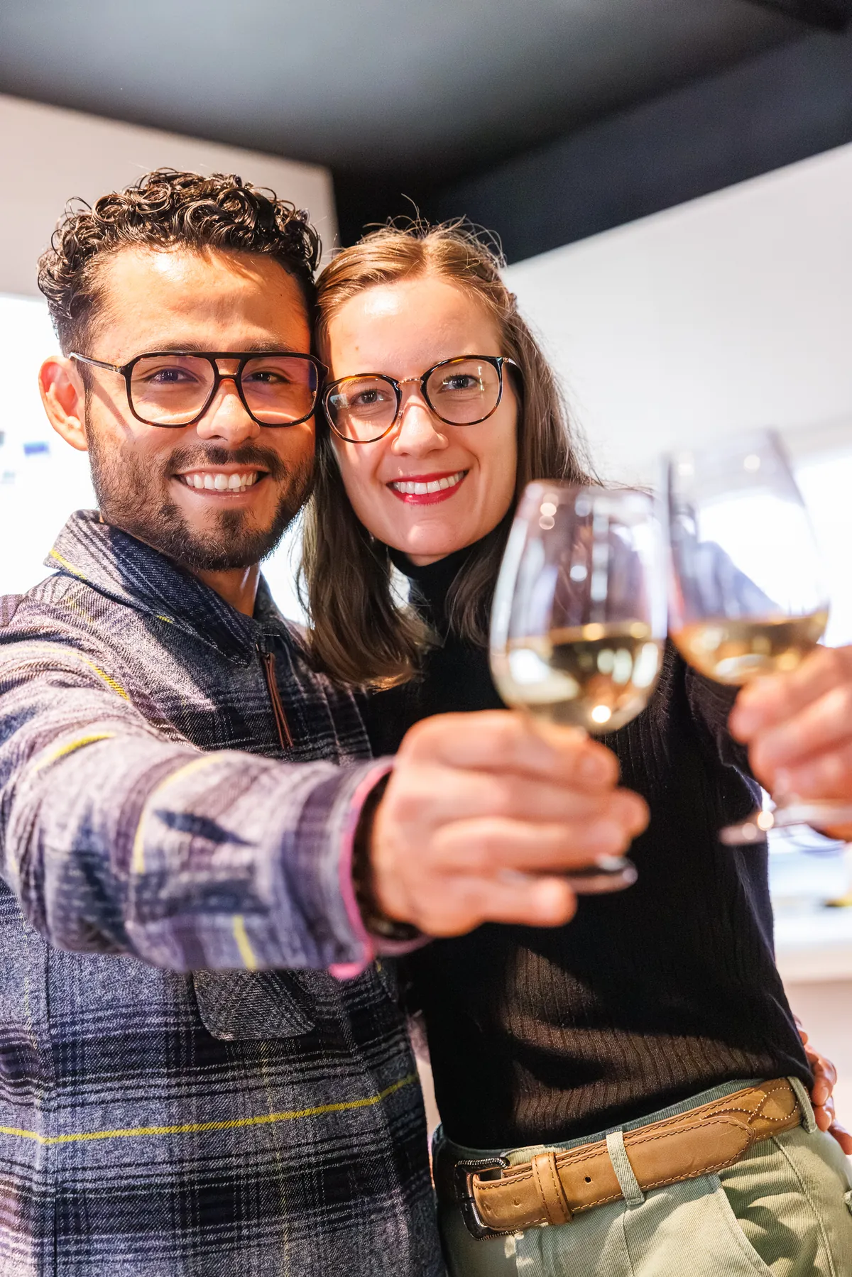 Couple of visitors raising a glass of Alsace white wine during the tasting, at the Vino Storia museum in Colmar