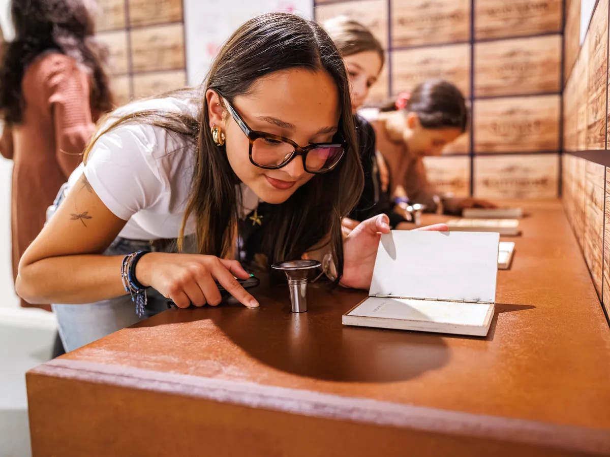 Una studentessa annusa un aroma al banco olfattivo dei grand cru