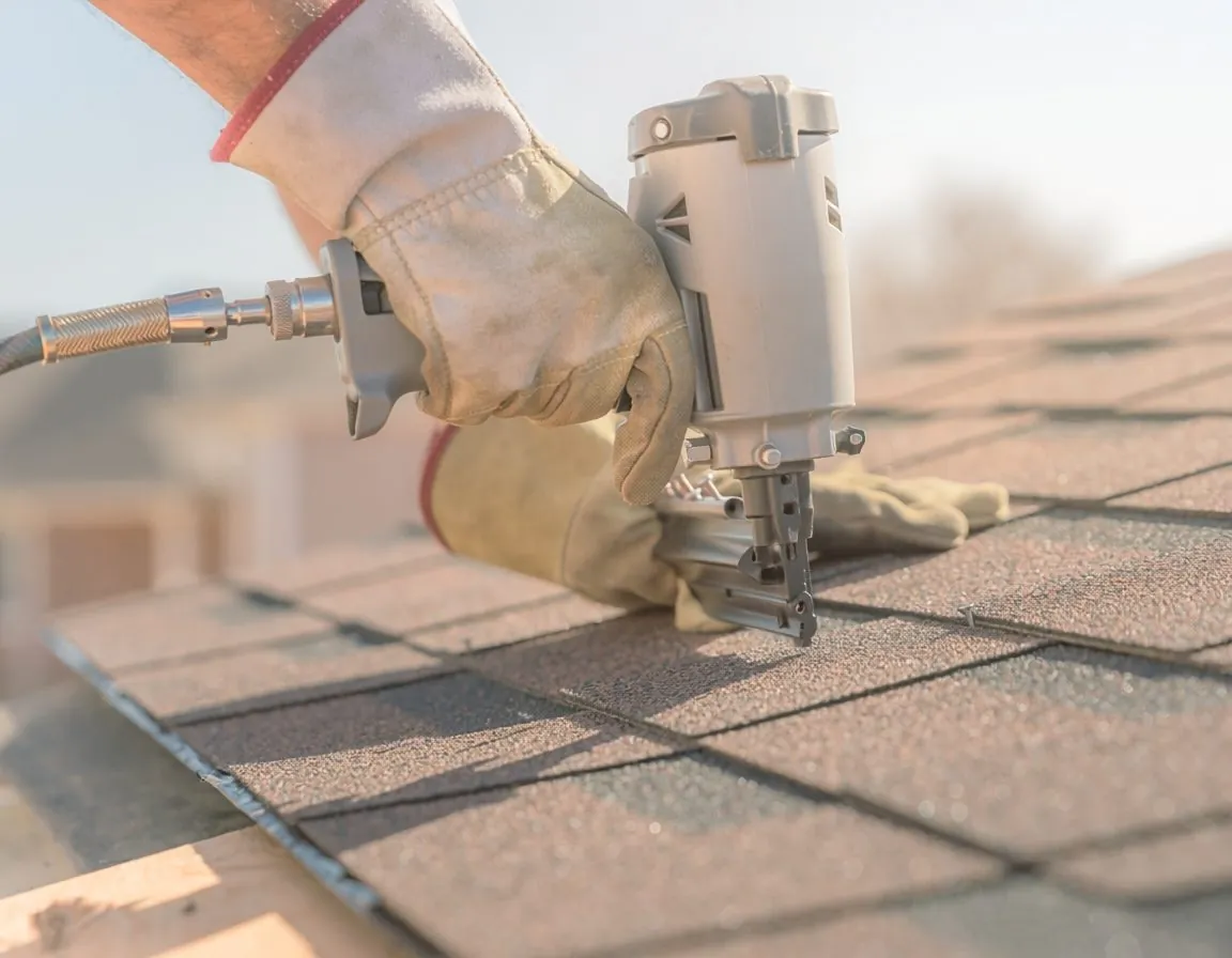 Roofer nailing architectural shingles