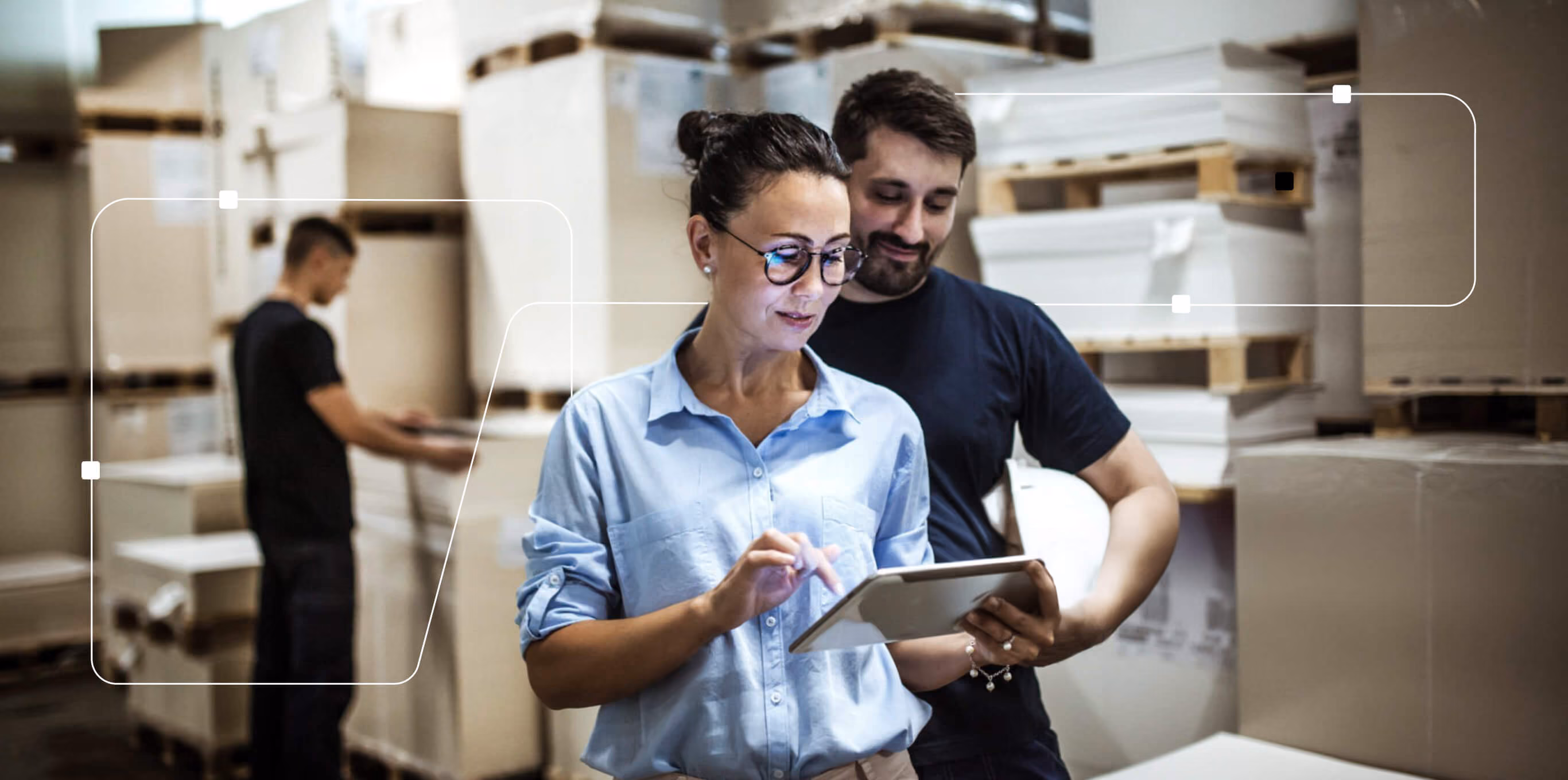 Two colleagues reviewing data on a tablet in a production hall