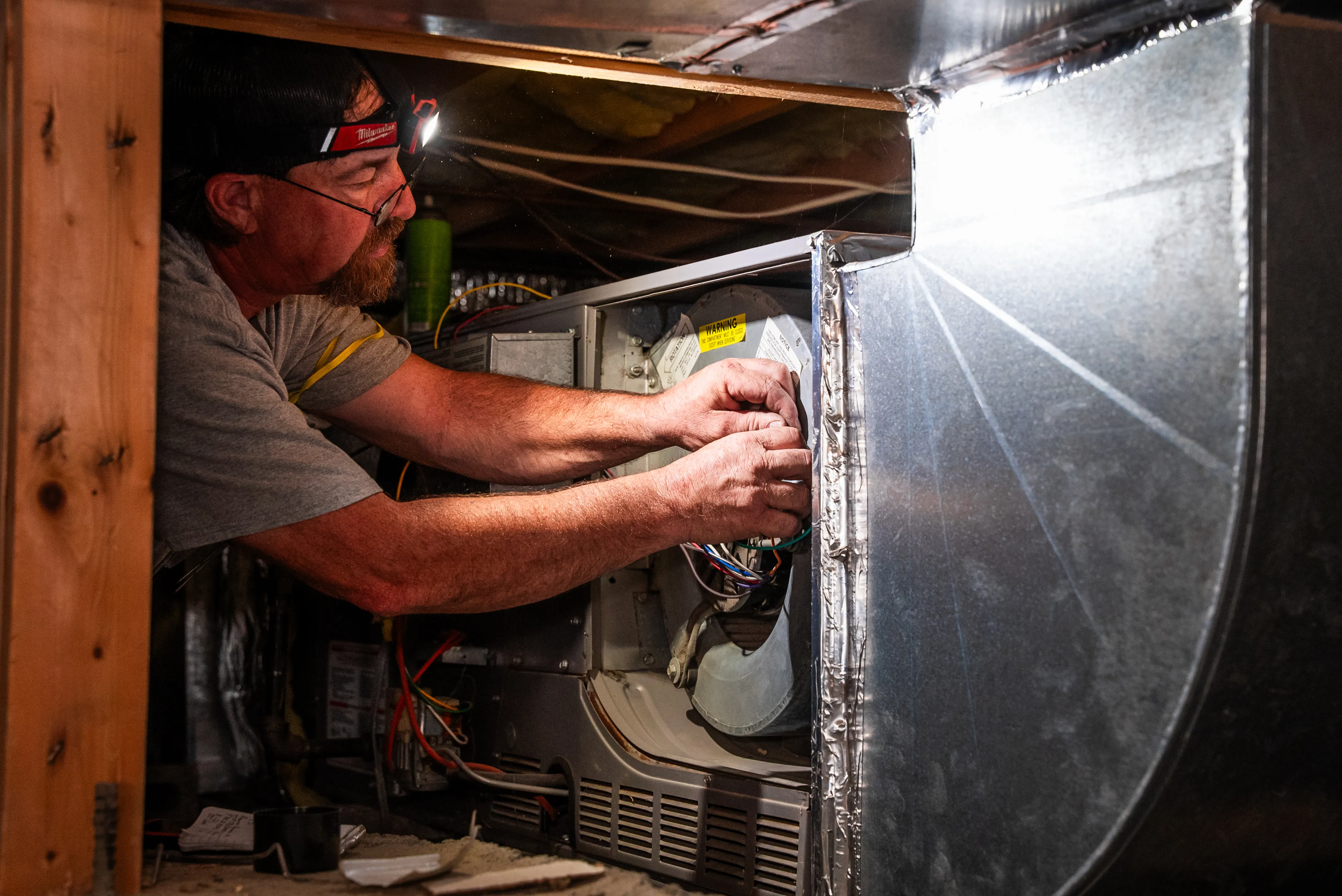 Snipps technician servicing a gas furnace before replacement in Montrose, CO