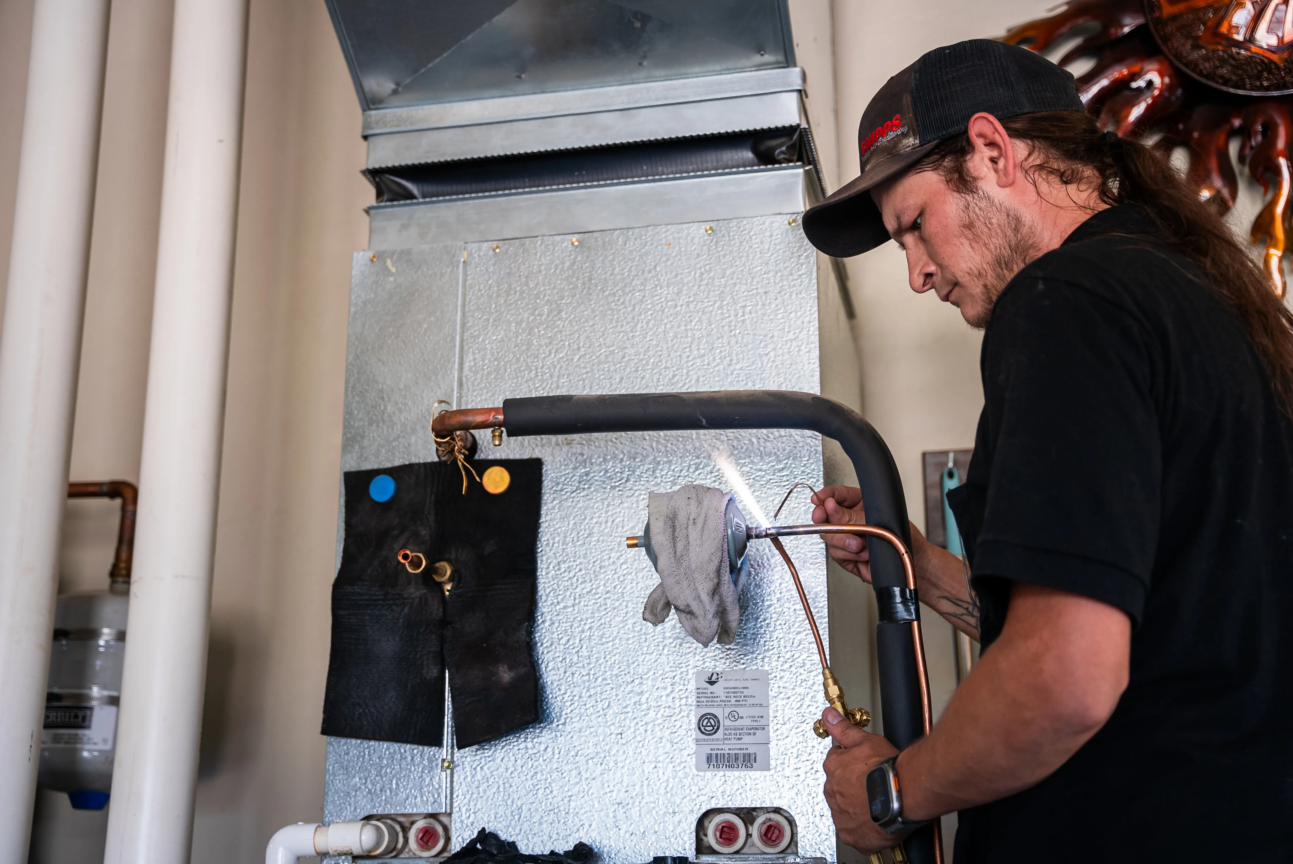 Technician working on an outdoor air conditioning condenser unit