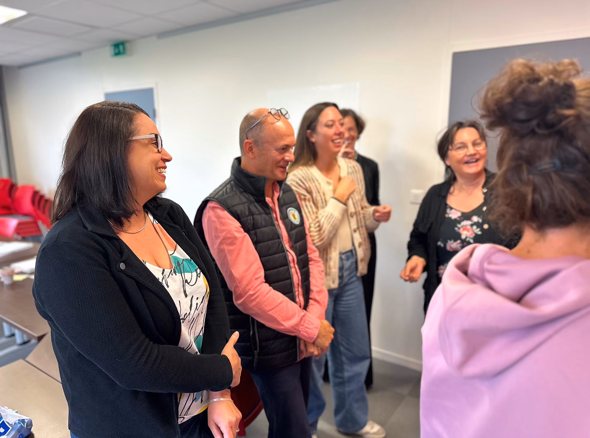 Participants d'un atelier debout, discutant et riant
