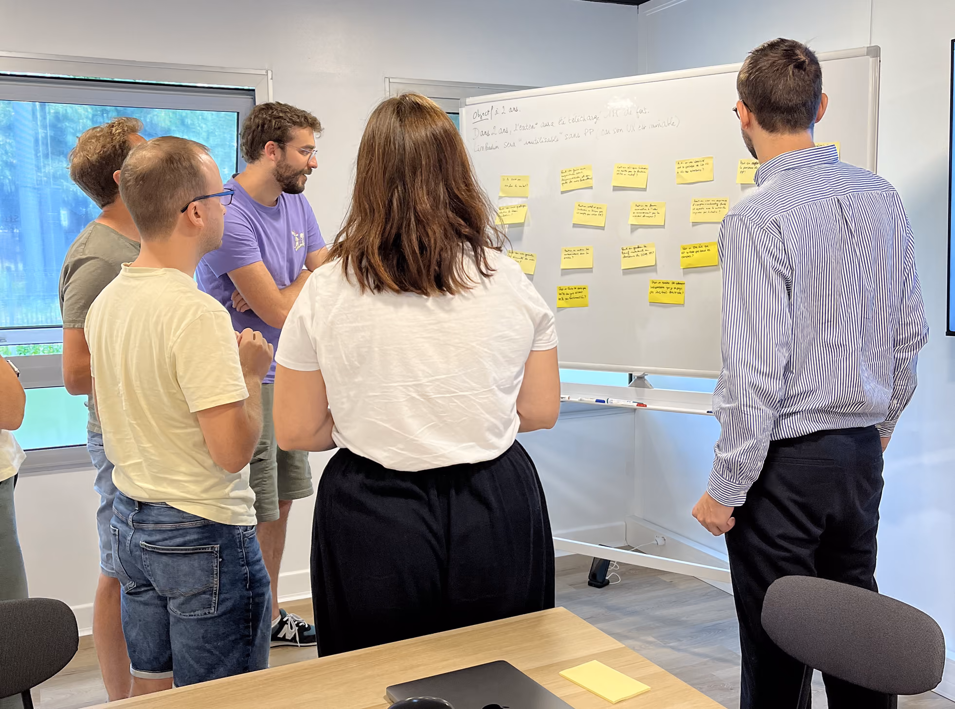 Participants collant des post-it sur un tableau blanc