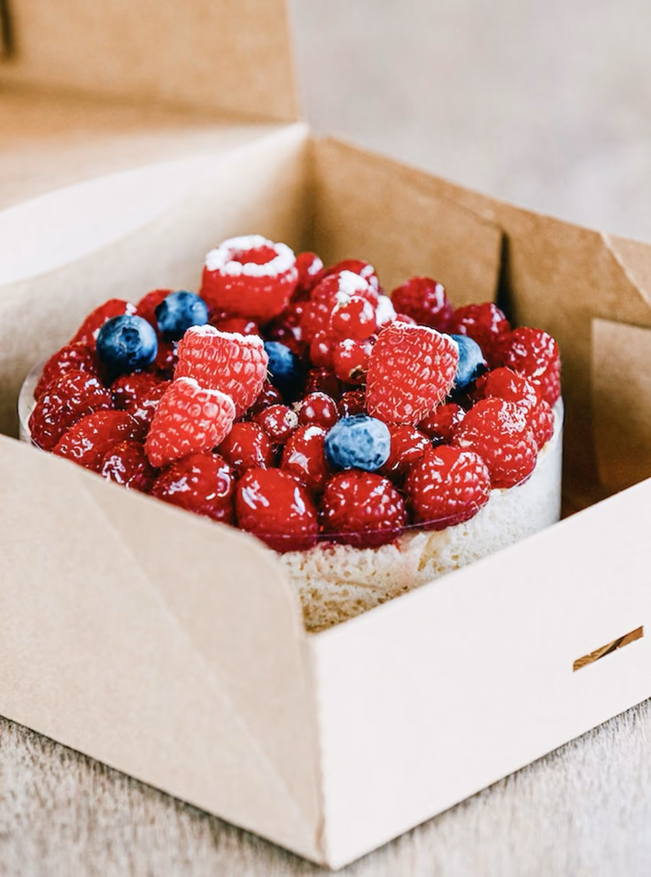 Boîte en carton kraft contenant un gâteau aux fruits rouges